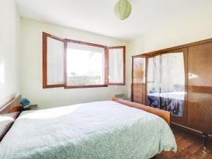 a bedroom with a large bed and a window at Maison plain-pied à Biscarrosse avec jardin clos, terrasse et parking pour 6 personnes - FR-1-521-105 in Biscarrosse
