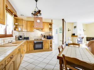 a kitchen with wooden cabinets and a table and a dining room at Maison plain-pied à Biscarrosse avec jardin clos, terrasse et parking pour 6 personnes - FR-1-521-105 in Biscarrosse +2 photos