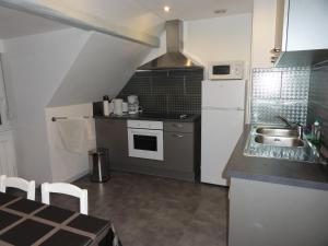 a kitchen with a sink and a white refrigerator at Gîte chez Jeanne in Ebersheim