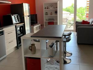 a kitchen with a table with a counter top at Appartement Moderne Centre-Ville Biscarrosse - Plage à Proximité - 4 Pers - WiFi et Parking Inclus - FR-1-319-443 in Biscarrosse