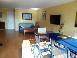 a living room with a blue table and a couch at Appartement 3 pièces en front de mer avec balcons, à Cabourg, proche centre-ville. - FR-1-487-275 in Cabourg +3 photos