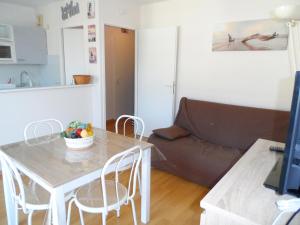 a living room with a table and a couch at Cabourg: Appartement 2 pièces proche plage avec piscine et parking - FR-1-487-299 in Cabourg