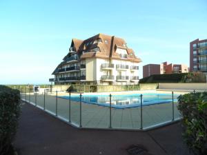 een gebouw met een zwembad voor een gebouw bij Appartement Cabourg, 2 pièces, 4 personnes - FR-1-487-170 in Cabourg