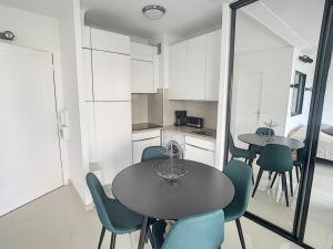 Studio Cannes, 1 pièce, 2 personnes - FR-1-470-50 في كان: مطبخ وغرفة طعام مع طاولة وكراسي