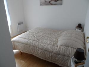 a bedroom with a bed with a white comforter at Cottage 3 pièces à Dives-sur-Mer, jardin privé, proche Port Guillaume, piscine, animaux acceptés - FR-1-487-301 in Dives-sur-Mer
