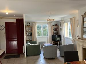 Una sala de estar con un sofá y sillas y un televisor. en Grande Villa avec Jardin, Proche Plage et Centre de Villers-sur-Mer - FR-1-487-310, en Villers-sur-Mer