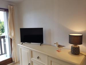 a tv sitting on top of a dresser with a lamp at Appartement Cabourg, 2 pièces, 4 personnes - FR-1-487-194 in Cabourg