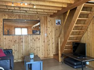 una sala de estar con una escalera en una cabaña de madera en Chalet Cabourg, 4 pièces, 6 personnes - FR-1-487-325 en Cabourg