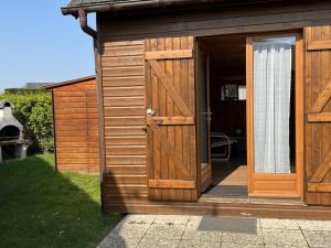 uma casa de banho de madeira com uma grande porta de madeira em Chalet Cabourg, 4 pièces, 6 personnes - FR-1-794-52 em Cabourg