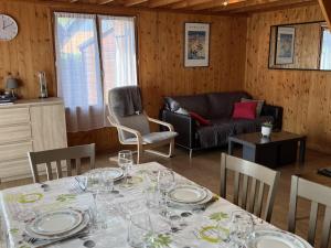 a dining room with a table and a couch at Chalet Cabourg, 4 pièces, 6 personnes - FR-1-487-325 in Cabourg