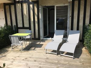 a group of chairs and a table on a patio at Studio Merville-Franceville-Plage, 1 pièce, 3 personnes - FR-1-487-222 in Merville-Franceville-Plage