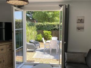 una puerta corredera de cristal que da a un patio con mesa y sillas en Maison Dives-sur-Mer, 3 pièces, 4 personnes - FR-1-487-320 en Dives-sur-Mer