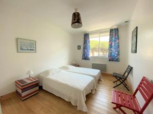 ein Schlafzimmer mit einem Bett, einem Stuhl und einem Fenster in der Unterkunft Maison Saint-Palais-sur-Mer, 5 pièces, 8 personnes - FR-1-539-22 in Saint-Palais-sur-Mer