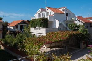 a white house with red roofs and ivy at Apartments Zivana in Zaboric