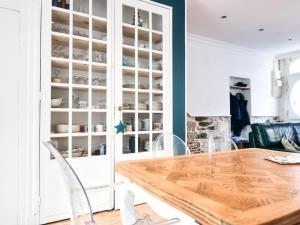 a dining room with a wooden table and white cabinets at Maison de Charme 4 Chambres, 50m de la Mer, Centre des Sables d'Olonne - FR-1-197-508 in Les Sables-dʼOlonne +24 photos