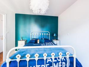 a bedroom with a bed with a blue wall at Maison de Charme 4 Chambres, 50m de la Mer, Centre des Sables d'Olonne - FR-1-197-508 in Les Sables-dʼOlonne