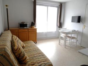 a living room with a couch and a table at Appartement 2 pièces avec piscine et parking à Dives-sur-Mer - FR-1-487-294 in Dives-sur-Mer +2 photos