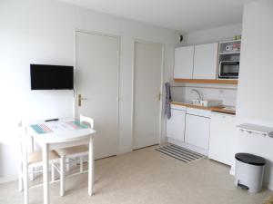 a small kitchen with a white table and chairs at Appartement 2 pièces avec piscine et parking à Dives-sur-Mer - FR-1-487-294 in Dives-sur-Mer