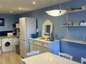 eine Küche mit blauen Wänden und einem weißen Kühlschrank in der Unterkunft Appartement Cabourg, 4 pièces, 6 personnes - FR-1-487-321 in Cabourg