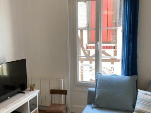 a living room with a blue couch and a window at Maison Cabourg, 4 pièces, 4 personnes - FR-1-487-215 in Cabourg