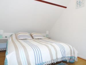 une chambre avec un lit avec deux oreillers dessus dans l'établissement Maison Cozy au Coeur de Cabourg avec Terrasse, Proche Plage, pour 4 Pers., Animaux Acceptés - FR-1-487-328, à Cabourg