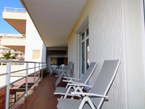 uma varanda com cadeiras e mesas num edifício em Appartement Saint-Cyprien, 3 pièces, 6 personnes - FR-1-309-307 em Saint-Cyprien