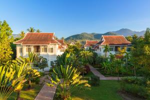a house with a garden in front of it at The Luang Say Residence in Luang Prabang