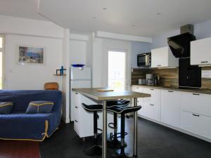 uma cozinha com uma mesa e um sofá azul em Appartement Saint-Cyprien, 3 pièces, 6 personnes - FR-1-309-307 em Saint-Cyprien