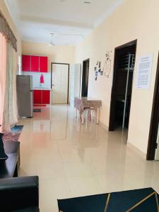 a kitchen with red cabinets and a table in it at Homestay Langkawi Guesthouse 3 Bedrooms in Pantai Cenang