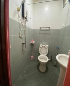 ein Bad mit einem WC und einem Waschbecken in der Unterkunft Homestay Langkawi Guesthouse 3 Bedrooms in Pantai Cenang