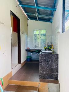 eine Küche mit einer Spüle und einer Arbeitsplatte in der Unterkunft Homestay Langkawi Guesthouse 3 Bedrooms in Pantai Cenang