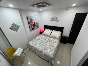 a small bedroom with a bed and a chair at Acogedor departamento junto al mar - Tonsupa in Tonsupa