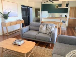 a living room with a couch and a table at Coast Yamba - Adults Only in Yamba