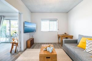 una sala de estar con un sofá y una mesa en 2 26 Voyager Cl waterfront ground floor unit, en Nelson Bay
