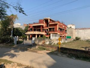 a red building sitting on the side of a street at Krimson Bricks Homestay in Varanasi