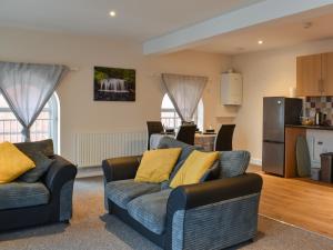 a living room with two couches and a kitchen at The Old Quaker House Apartment in Llandrindod Wells