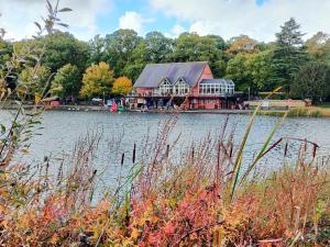 a large house sitting on the side of a lake at The Old Quaker House Apartment in Llandrindod Wells