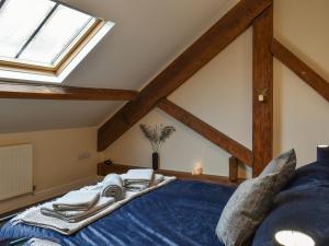 een slaapkamer met een groot blauw bed en een dakraam bij The Old Quaker House Apartment in Llandrindod Wells