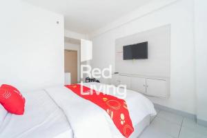 a white bedroom with a red blanket on a bed at RedLiving Apartemen JP Bogor - Fix Room in Kedungbadak