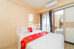 a bedroom with a white bed and a window at RedLiving Apartemen JP Bogor - Fix Room in Kedungbadak