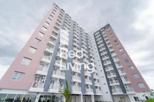 two tall buildings with the beijing sign on them at RedLiving Apartemen JP Bogor - Fix Room in Kedungbadak