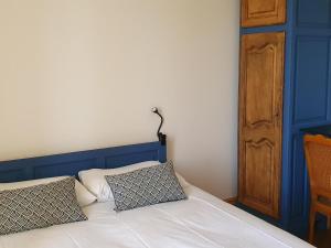 uma cama com uma cabeceira azul e duas almofadas em Gîte Cindré, 5 pièces, 10 personnes - FR-1-489-406 em Cindré