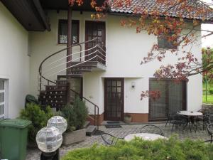 a house with a porch and a balcony at Apartment Sobe Ravbar in Novo Mesto