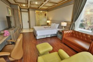 ホーチミン・シティにあるLotus Saigon Hotelのベッドとソファ付きのホテルルーム