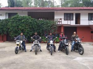 a group of men on motorcycles parked in front of a building at Shree Raksha Homestay in Gonikoppal