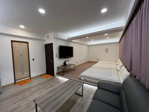 a living room with a bed and a tv at Tamshui Homestay in Tamsui
