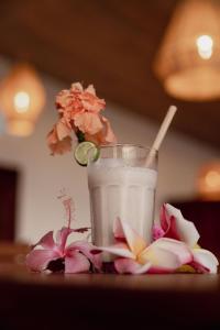 a glass of milk and flowers on a table at Belamandy Lodge in Anjramarango