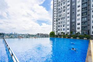 a person swimming in a pool in front of two tall buildings at Căn hộ cao cấp 3 sao quận 10 - Hong Dao House in Ho Chi Minh City