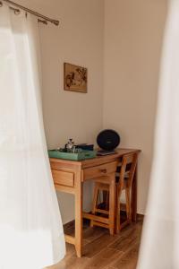 escritorio de madera en una habitación con ventana en Belamandy Lodge en Anjramarango