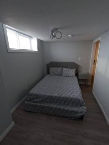a bedroom with a bed and a window at Gorgeous Basement Apartment in Calgary